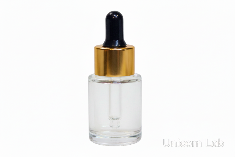 Clear 15ml flat shoulder glass dropper bottle with gold cap on a white background