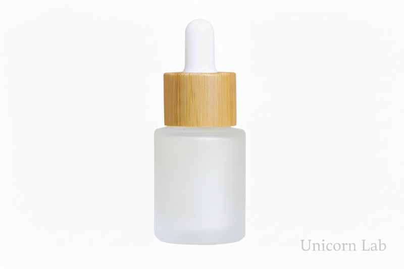 Frosted glass 15ml flat shoulder dropper bottle with wooden cap on a white background