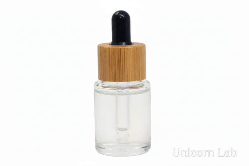Clear 5ml flat shoulder glass dropper bottle with a bamboo cap on a white background