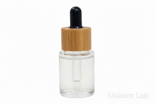 Clear 5ml flat shoulder glass dropper bottle with a bamboo cap on a white background