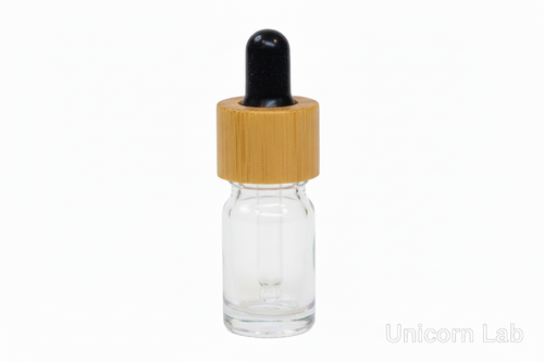 Clear glass  5ml round dropper bottle with a bamboo cap on a white background