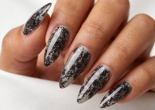 Hand with black and white floral nail art on a white background