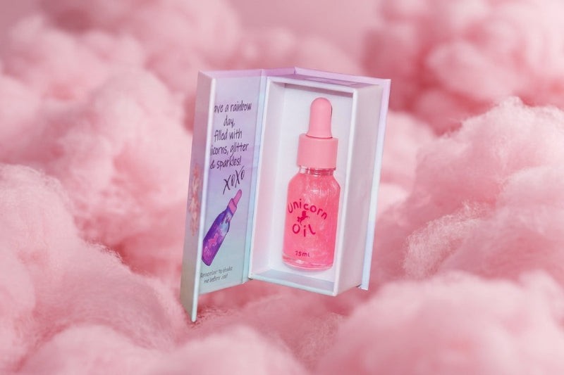 Fairy Floss Shimmer Cuticle Oil with packaging on a pink fluffy background