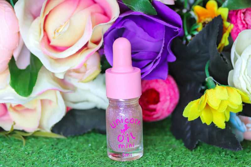 Floral Explosion Unicorn Cuticle Oil 5ml mini size Infront of mixed coloured flowers. 