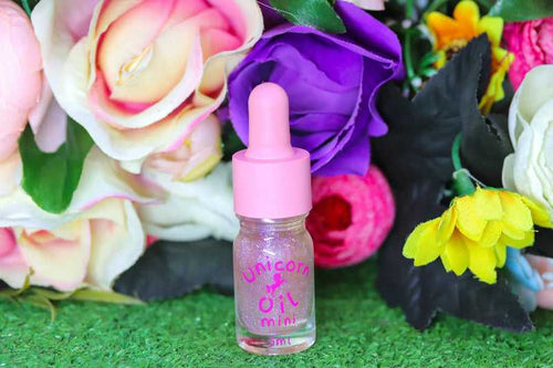 Floral Explosion Unicorn Cuticle Oil 5ml mini size Infront of mixed coloured flowers. 