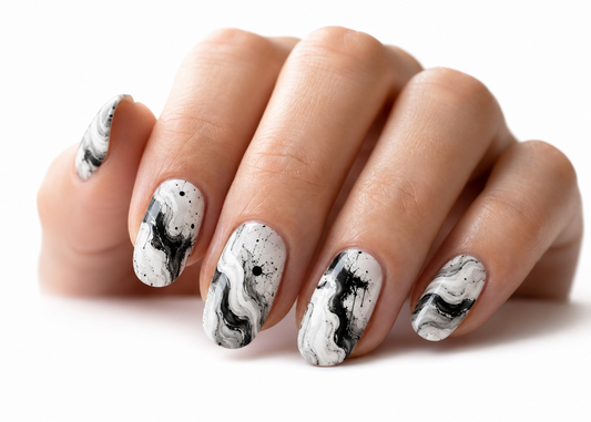 Nail art with black and white abstract design on a neutral background