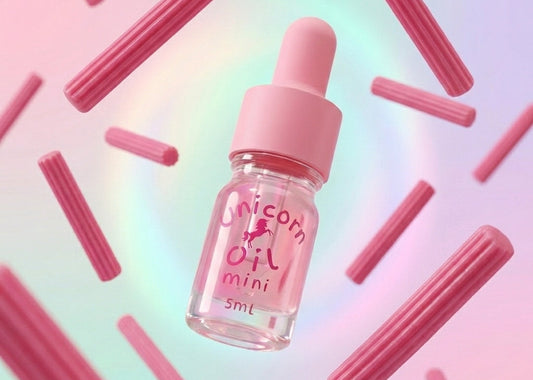 Pink bottle labeled 'Unicorn Oil mini' on a colorful background with pink cylindrical objects.