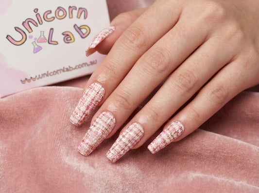 Hand with pink glittery nails on a pink surface, with 'Unicorn Lab' branding in the background. Soft Pink Tweed Waterslide nail Decals