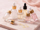 Set of skincare serum bottles with droppers on a soft pink background - Private label nail serum by unicorn lab