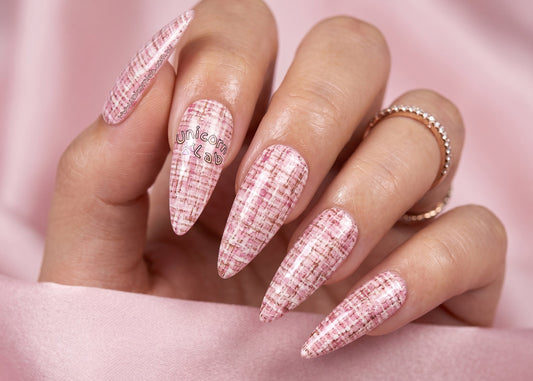 Hand with pink textured nails on a pink background. Soft Pink Tweed Water slide nail Decals