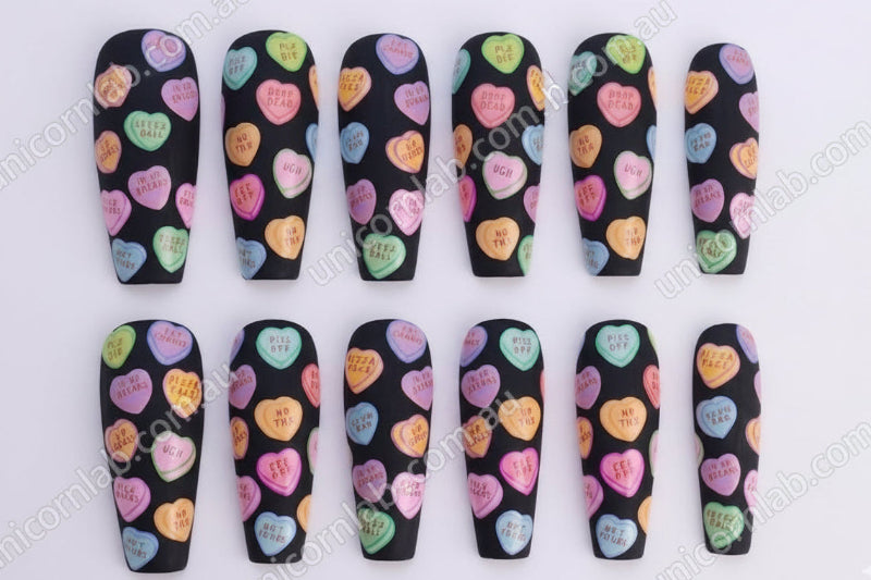 Nail art design with colorful heart shapes on a black background - Unicorn Lab