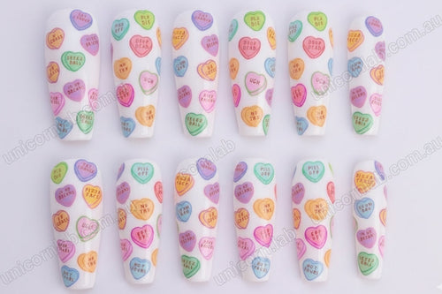 Anti Valentine Candy Hearts waterslide decal displayed on a white set of coffin nails - Unicorn Lab