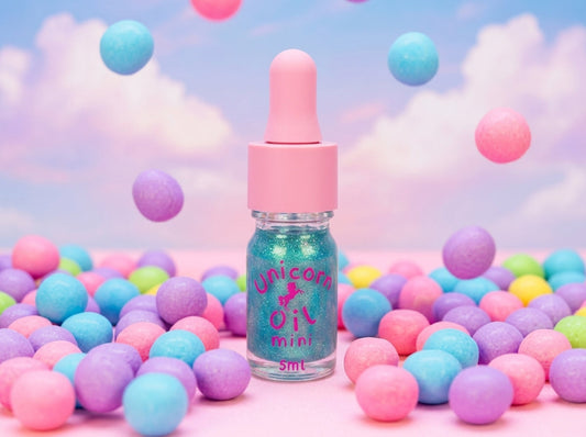 A bubblegum scented 5ml mini cuticle oil  from Unicorn Lab surrounded by colourful gumballs