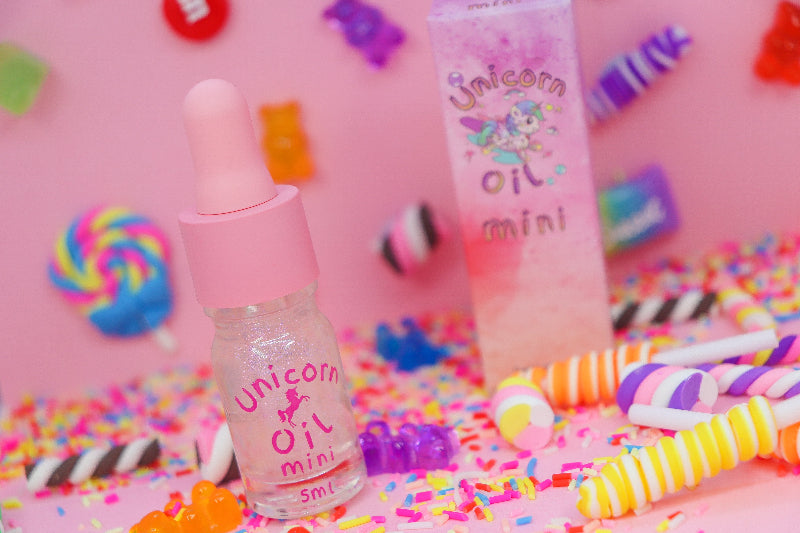 Two small bottles labeled 'Unicorn Oil mini' on a colorful candy-themed background. - Australian made scented cuticle oil