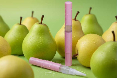 Pink pen cuticle oil with a white tip on a green background with pears