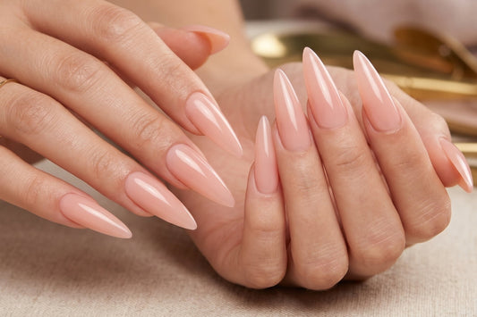 Close-up of hands with long, pointed nails on a neutral background