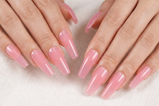 Close-up of hands with pink nail polish on a light background