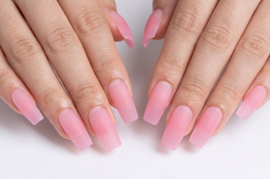 Close-up of hands with pink nail polish on a white background
