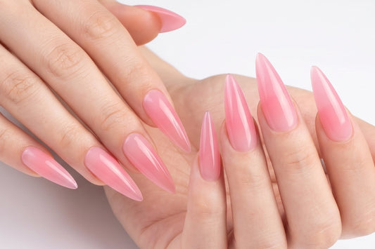 Close-up of hands with pink nail polish on a white background