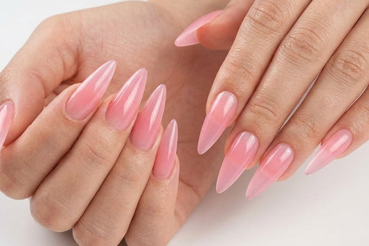 Close-up of hands with pink nail polish on a light background