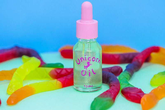 15ml glass bottle of Killer Python Unicorn Cuticle Oil with coloured gummy snaked lollies