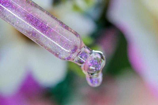 A detailed macro image of Floral Explosion Unicorn Cuticle Oil -the shimmer inside dropper is starting to drip out